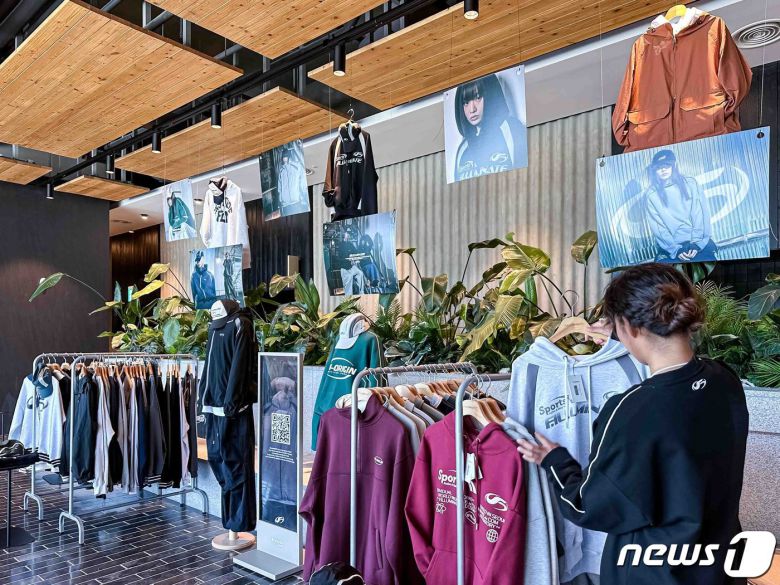 브리드호텔 양양 로비에 전시된 필루미네이트 의류를 고객이 보고 있다(한화호텔앤드리조트 제공).