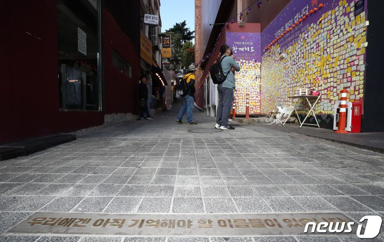 10.29 이태원 참사 1주기를 앞둔 27일 서울 용산구 이태원역 1번 출구 앞 골목 초입에 '우리에겐 아직 기억해야 할 이름들이 있습니다'라는 바닥명판이 새겨져 있다. 정부는 핼러윈 기간 인파 밀집 위험도가 높을 것으로 예상되는 서울 이태원과 홍대, 명동, 대구 동성로 등 4곳을 집중적으로 관리하기로 했다. 2023.10.27/뉴스1 ⓒ News1 박세연 기자