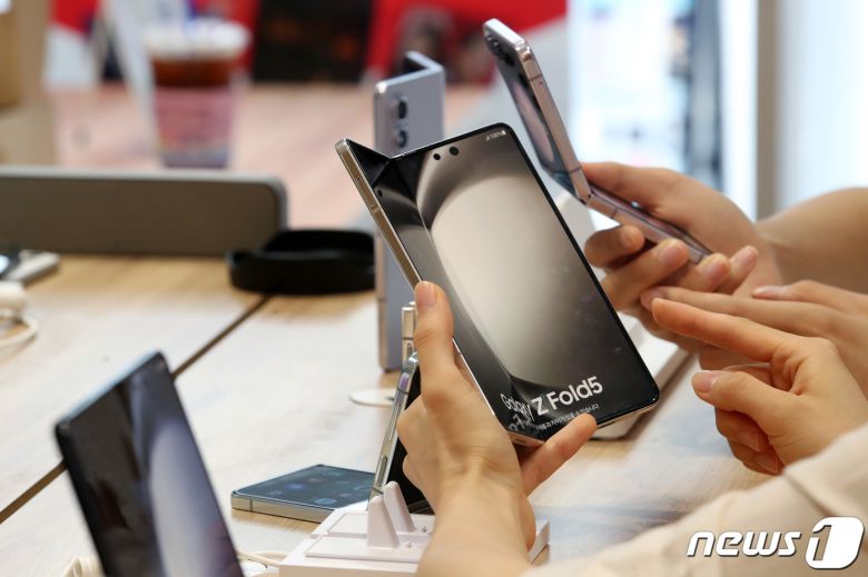 KT를 비롯한 이동통신사 3사의 갤럭시Z플립5과 폴드5의 사전 예약을 하루 앞둔 31일 오전 서울 종로구 KT 플라자 광화문역점에서 관계자들이 갤럭시Z플립5와 폴드5를 살펴보고 있다. 갤럭시 Z플립5와 Z폴드5는 오는 8월 1~7일 사전 판매를 진행하며, 8월 11일 국내 정식 출시된다. 2023.7.31/뉴스1 ⓒ News1 이동해 기자