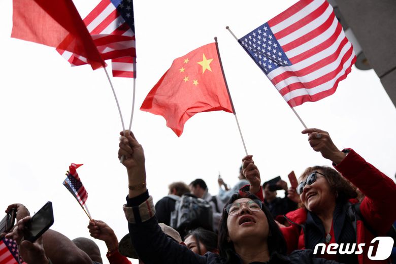 시진핑 중국 국가주석이 14일(현지시간) 미중 정상회담과 아시아태평양경제협력체(APEC) 정상회의에 참석하기 위해 캘리포니아주 샌프란시스코 국제 공항에 도착한 가운데, 지지자들이 오성홍기와 성조기를 들며 그의 방문을 환영하고 있다. ⓒ 로이터=뉴스1 ⓒ News1 정윤영 기자