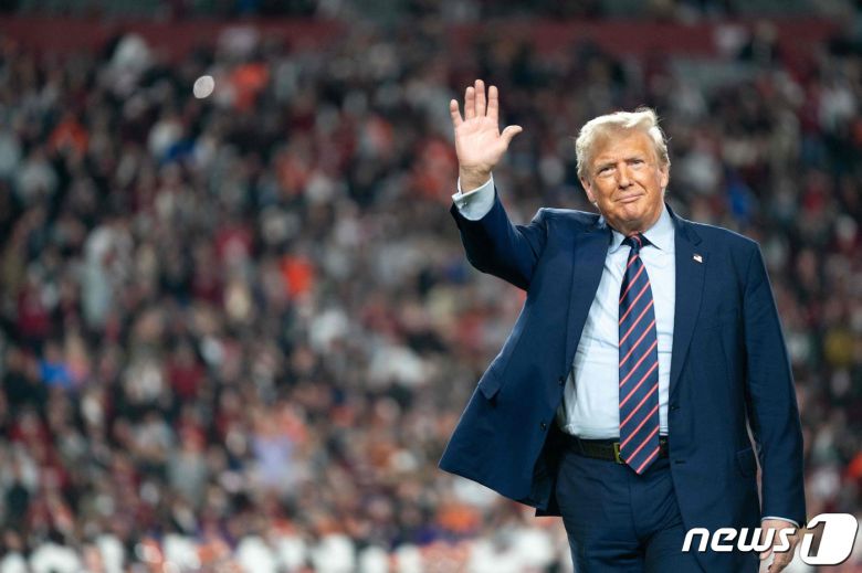 도널드 트럼프 전 미국 대통령이 지난달 25일(현지시간) 사우스캐롤라이나주 컬럼비아에서 열린 대학 미식축구 경기 하프타임 동안 그라운드서 관중에게 손을 흔들고 있다. 2023.11.27 ⓒ AFP=뉴스1 ⓒ News1 우동명 기자