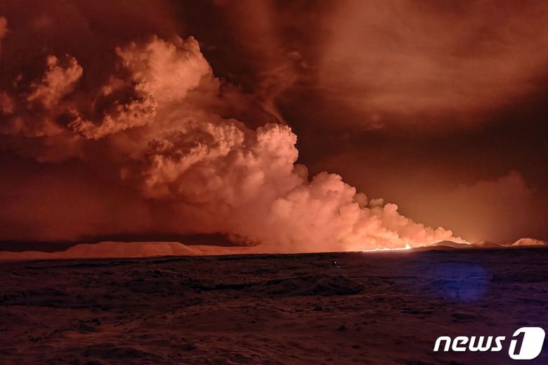 18일(현지시간) 아이슬란드 남서부 레이캬비크 반도의 그린다비크 지역에서 화산이 폭발해 하늘이 빨갛게 보이는 가운데 화산재가 뿜어져 나오고 있다. 2023.12.18 ⓒ AFP=뉴스1 ⓒ News1 정지윤 기자