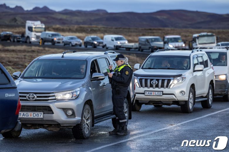 아이슬란드 그린다비크 지역에서 화산 활동으로 인해 주민들이 대피한 가운데 마을을 떠났던 주민들이 16일(현지시간) 집에서 소지품을 가져오기 위해 인근 도로에서 대기하고 있다. 2023.11.17 ⓒ 로이터=뉴스1 ⓒ News1 정지윤 기자