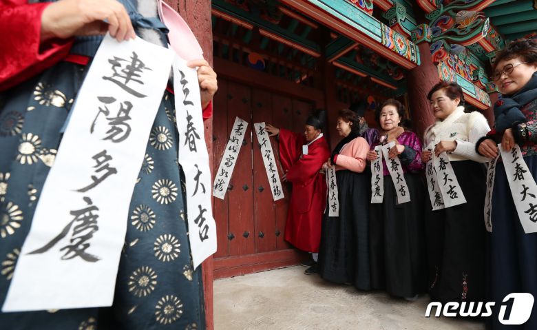 봄의 시작을 알리는 첫번째 절기 입춘(立春)을 사흘 앞둔 1일 부산 동래구 동래향교에서 지역 유림 대표들이 입춘첩을 외삼문에 붙이고 있다. 2024.2.1/뉴스1 ⓒ News1 윤일지 기자