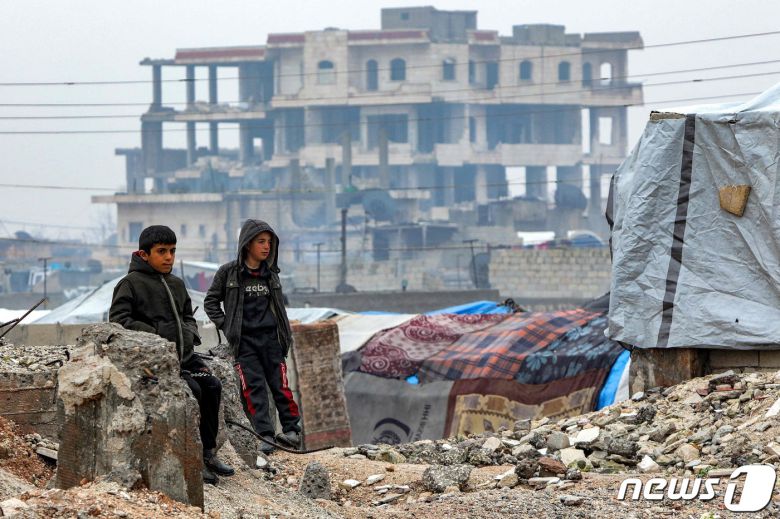 튀르키예·시리아 대지진 일주기를 사흘 앞둔 3일(현지시간) 시리아 북부도시 알레포 인근 진다레스 마을에서 외벽이 떨어진 건물 앞에서 천막생활을 하는 아이들이 서성이고 있다. 2024.1.3. ⓒ AFP=뉴스1 ⓒ News1 김성식 기자