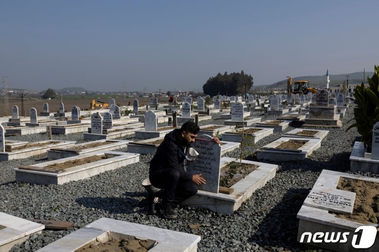 튀르키예·시리아 대지진 일주기를 닷새 앞둔 1일(현지시간) 튀르키예 남동부 하타이주에서 한 남성이 지진 희생자 묘역에 무릎을 굽힌 채 묘비를 어루만지고 있다. 2024.2.1. ⓒ 로이터=뉴스1 ⓒ News1 김성식 기자