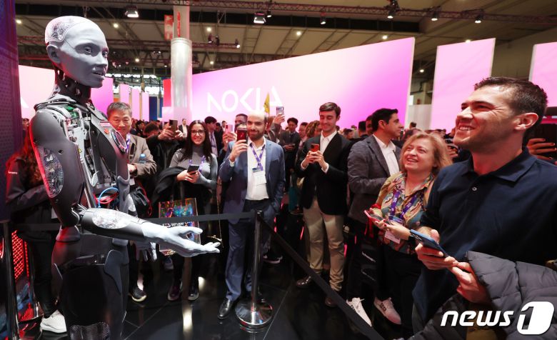 세계 최대 이동통신 전시회 '모바일 월드 콩그레스(MWC) 2024’ 이튿날인 27일 오전(현지시간) 스페인 바르셀로나 피라 그란 비아 전시장 e& 부스에 AI 로봇이 관람객들과 대화를 하고 있다. 2024.2.27/뉴스1 ⓒ News1 김민지 기자