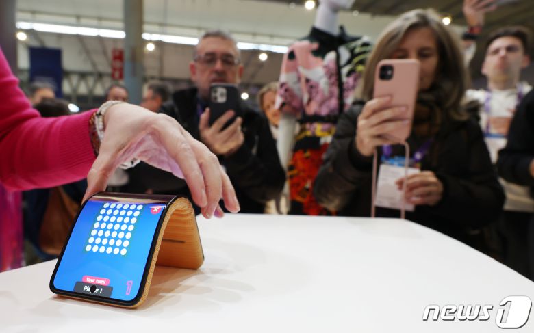 세계 최대 이동통신 전시회 '모바일 월드 콩그레스(MWC) 2024’ 이튿날인 27일 오전(현지시간) 스페인 바르셀로나 피라 그란 비아 전시장에 마련된 모토로라 부스에서 관람객들이 화면을 구부린 채 사용할 수 있는 벤더블폰 제품을 보고 있다. 2024.2.27/뉴스1 ⓒ News1 김민지 기자
