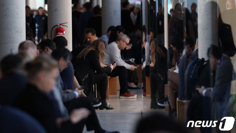 세계 최대 이동통신 전시회 모바일 월드 콩그레스(MWC) 2024 폐막을 하루 앞둔 28일 오후(현지시간) 스페인 바르셀로나 피라 그란 비아 전시장에서 관람객들이 스마트폰을 사용하고 있다. 2024.2.28/뉴스1 ⓒ News1 김민지 기자