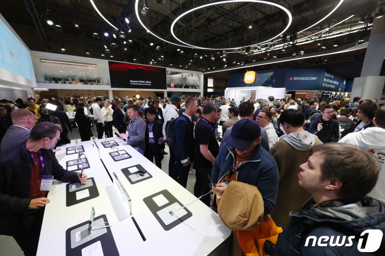 세계 최대 이동통신 전시회 '모바일 월드 콩그레스(MWC) 2024’ 개막일인 26일 오전(현지시간) 스페인 바르셀로나 피아 그란 비아 전시장에 마련된 샤오미 부스에서 관람객들이 라이카와 협업한 샤오미14 울트라를 체험하고 있다. 2024.2.26/뉴스1 ⓒ News1 김민지 기자