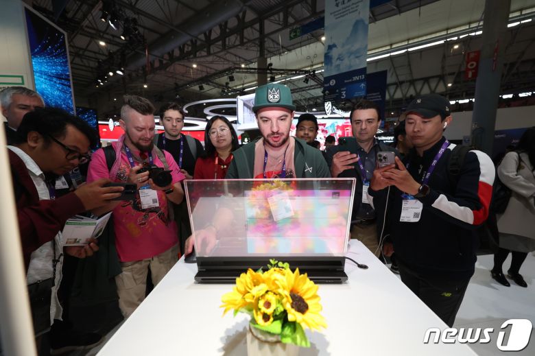 세계 최대 이동통신 전시회 '모바일 월드 콩그레스(MWC) 2024’ 개막일인 26일 오후(현지시간) 스페인 바르셀로나 피아 그란 비아 전시장에 마련된 레노버 부스에서 관람객들이 투명 디스플레이를 장착한 노트북을 살펴보고 있다. 2024.2.26/뉴스1 ⓒ News1 김민지 기자
