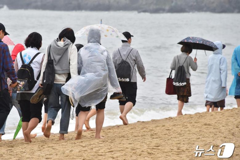 21일 오후 해운대해수욕장 일원에서 세븐 비치 어싱 챌린지 참가자들이 백사장을 걷고 있다(부산시청 제공)