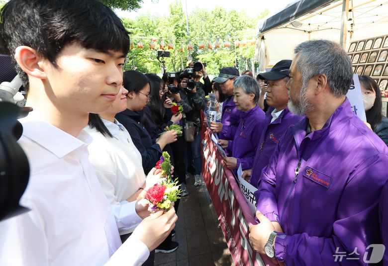 10.29 이태원 참사 유가족들이 8일 오전 서울 중구 서울광장 분향소 앞에서 열린 '10.29 이태원참사 온전한 진상규명을 위해 거리에서 맞는 두 번째 어버이날 행사'에서 학생들에게 카네이션을 받고 있다. 2024.5.8/뉴스1 ⓒ News1 김진환 기자