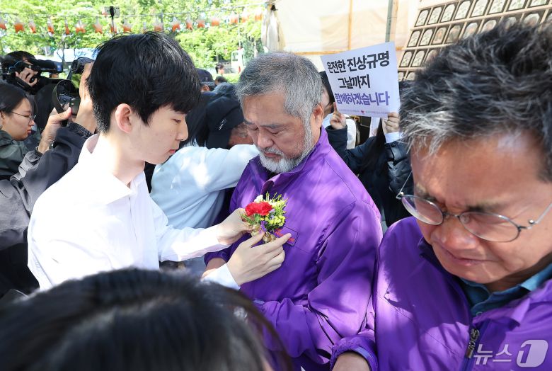 이정민 10.29 이태원 참사 유가족협의회 운영위원장을 비롯한 유가족들이 8일 오전 서울 중구 서울광장 분향소 앞에서 열린 '10.29 이태원참사 온전한 진상규명을 위해 거리에서 맞는 두 번째 어버이날 행사'에서 학생들에게 카네이션을 받고 있다. 2024.5.8/뉴스1 ⓒ News1 김진환 기자