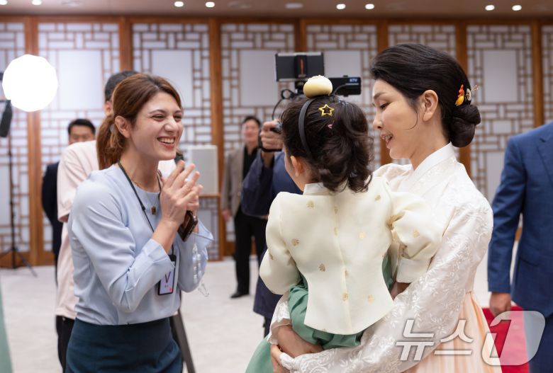 윤석열 대통령과 부인 김건희 여사가 한가위 명절 인사를 전했다고 대통령실이 13일 밝혔다. 이번 한가위 영상은 지난 8일 대통령실 2층 자유홀에서 1시간에 걸쳐 촬영됐다. 사진은 김건희 여사가 어린이를 안고 대화를 나누는 모습. (대통령실 제공) 2024.9.13/뉴스1 ⓒ News1 송원영 기자