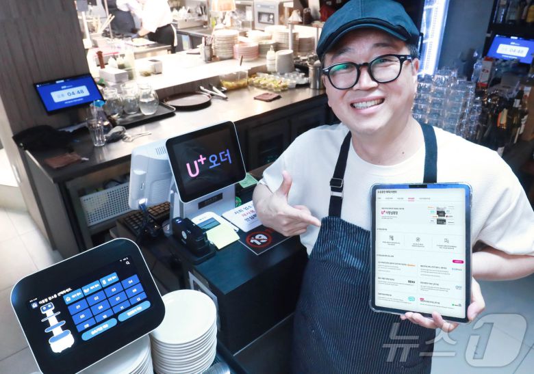 지난 4월 LGU+ '식당연구소' 프로젝트로 문을 연 파브리키친 내부에서 관계자가 'U+우리가게패키지'를 설명하는 태블릿 화면을 들어 보이고 있다 (LG유플러스 제공). 2024.10.10/뉴스1