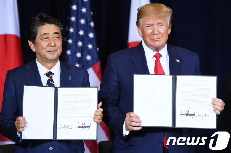 도널드 트럼프 미국 대통령이 25일(현지시간) 뉴욕 유엔본부에서 열린 유엔총회 중 아베 신조 일본 총리와 서명한 무역협정을 들어보이고 있다. ⓒ AFP=뉴스1 ⓒ News1 우동명 기자