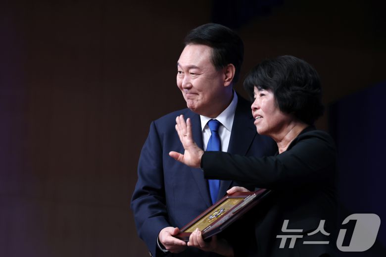 윤석열 대통령이 21일 서울 서대문구 경찰청 참수리홀에서 열린 79주년 경찰의 날 기념식에서 故 이재현 경장의 모친 유진숙 씨에게 '경찰 영웅패'를 전달한 뒤 기념촬영을 하고 있다. (대통령실 제공) 2024.10.21/뉴스1 ⓒ News1 송원영 기자