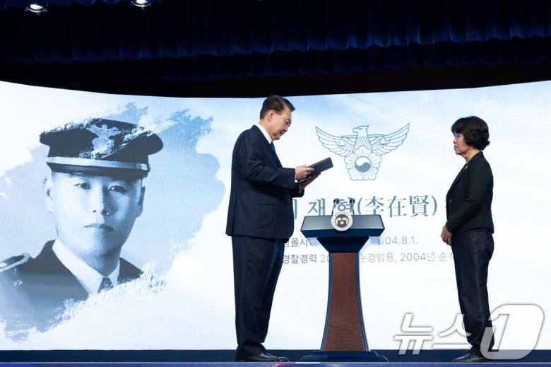 윤석열 대통령이 21일 서울 서대문구 경찰청 참수리홀에서 열린 79주년 경찰의 날 기념식에서 故 이재현 경장의 모친 유진숙 씨에게 '경찰 영웅패'를 전달하고 있다. (대통령실 제공) 2024.10.21/뉴스1 ⓒ News1 송원영 기자