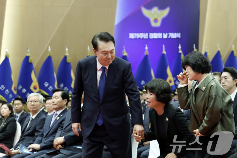 윤석열 대통령이 21일 서울 서대문구 경찰청 참수리홀에서 열린 79주년 경찰의 날 기념식에서 '경찰 영웅패' 전달을 위해 故 이재현 경장의 모친 유진숙 씨, 故 심재호 경위의 배우자 황옥주 씨와 단상으로 향하고 있다. (대통령실 제공) 2024.10.21/뉴스1 ⓒ News1 송원영 기자