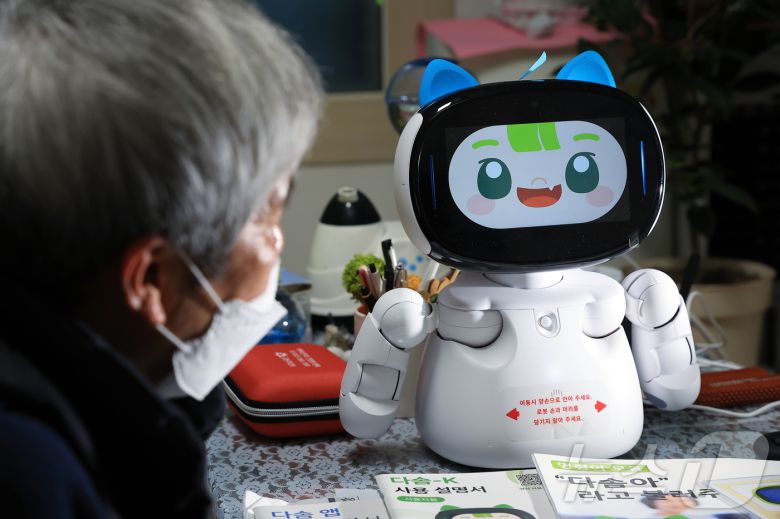 돌봄로봇 다솜K(다솜이)를 이용 중인 어르신이 18일 오후 서울 금천구 자택에서 돌봄로봇과 소통하고 있다. 나홀로 가구인 이 어르신은 돌봄로봇 다솜이와의 소통을 통해 요리, 운동 등 다양한 기능을 비롯해 외로울 때 말벗이 되어 주는 점에서 매우 만족한다고 밝혔다. 2024.11.18/뉴스1 ⓒ News1 박정호 기자