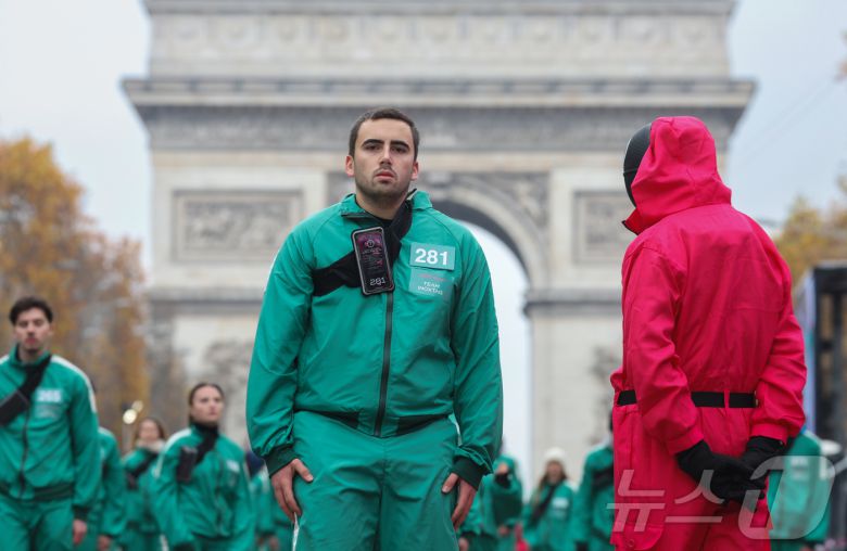 11일(현지시간) 프랑스 파리 샹젤리제 거리에서 열린 넷플릭스 오리지널 시리즈 ‘오징어게임’ 재현 현장 이벤트에서 참가자들이 드라마 속 게임인 ‘무궁화꽃이 피었습니다’에 참여하고 있다.  2024.12.2/뉴스1 ⓒ News1 이준성 기자