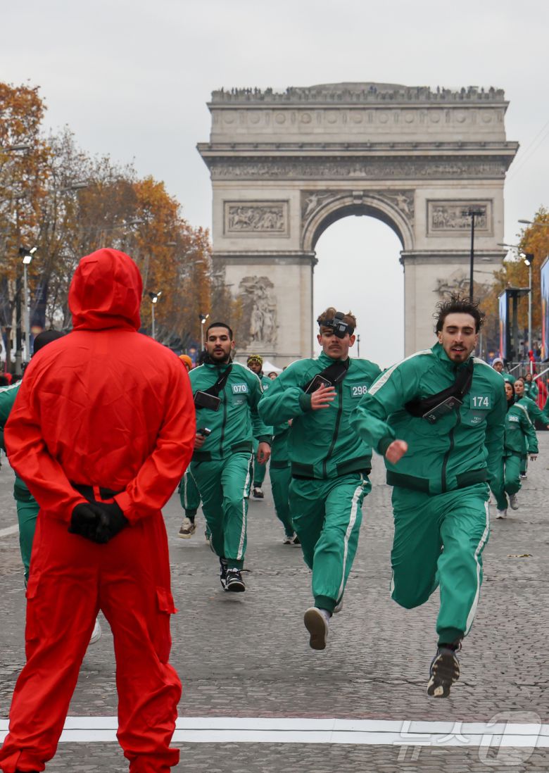 11일(현지시간) 프랑스 파리 샹젤리제 거리에서 열린 넷플릭스 오리지널 시리즈 ‘오징어게임’ 재현 현장 이벤트에서 참가자들이 드라마 속 게임인 ‘무궁화꽃이 피었습니다’에 참여하고 있다.  2024.12.2/뉴스1 ⓒ News1 이준성 기자