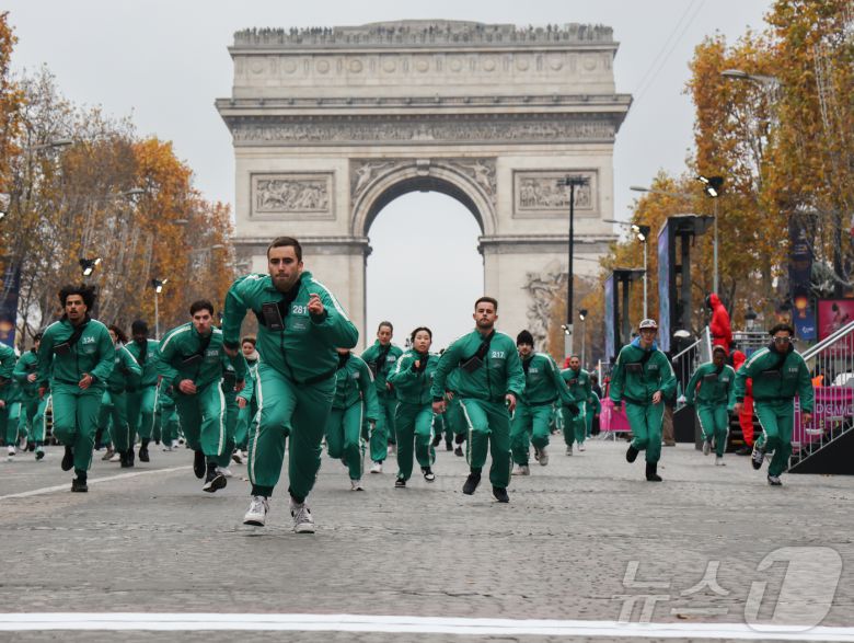 1일(현지시간) 프랑스 파리 샹젤리제 거리에서 열린 넷플릭스 오리지널 시리즈 ‘오징어게임’ 재현 현장 이벤트에서 참가자들이 드라마 속 게임인 ‘무궁화꽃이 피었습니다’에 참여하고 있다.  2024.12.2/뉴스1 ⓒ News1 이준성 기자