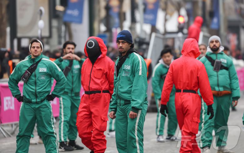 1일(현지시간) 프랑스 파리 샹젤리제 거리에서 열린 넷플릭스 오리지널 시리즈 ‘오징어게임’ 재현 현장 이벤트에서 참가자들이 드라마 속 게임인 ‘무궁화꽃이 피었습니다’에 참여하고 있다.  2024.12.2/뉴스1 ⓒ News1 이준성 기자