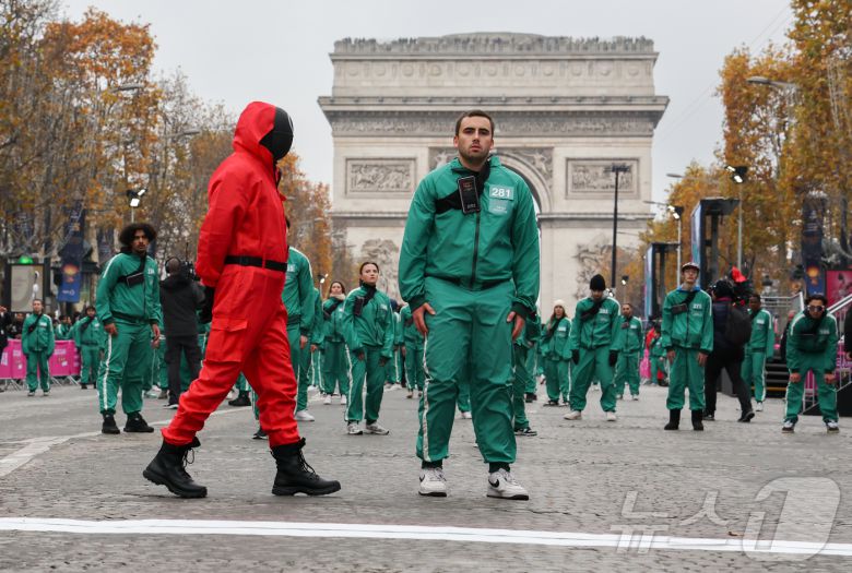 1일(현지시간) 프랑스 파리 샹젤리제 거리에서 열린 넷플릭스 오리지널 시리즈 ‘오징어게임’ 재현 현장 이벤트에서 참가자들이 드라마 속 게임인 ‘무궁화꽃이 피었습니다’에 참여하고 있다.  2024.12.2/뉴스1 ⓒ News1 이준성 기자