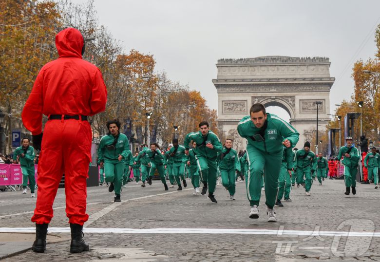 11일(현지시간) 프랑스 파리 샹젤리제 거리에서 열린 넷플릭스 오리지널 시리즈 ‘오징어게임’ 재현 현장 이벤트에서 참가자들이 드라마 속 게임인 ‘무궁화꽃이 피었습니다’에 참여하고 있다.  2024.12.2/뉴스1 ⓒ News1 이준성 기자