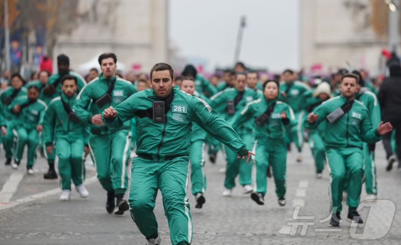 1일(현지시간) 프랑스 파리 샹젤리제 거리에서 열린 넷플릭스 오리지널 시리즈 ‘오징어게임’ 재현 현장 이벤트에서 참가자들이 드라마 속 게임인 ‘무궁화꽃이 피었습니다’에 참여하고 있다.  2024.12.2/뉴스1 ⓒ News1 이준성 기자
