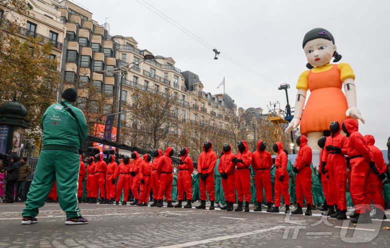 1일(현지시간) 프랑스 파리 샹젤리제 거리에서 열린 넷플릭스 오리지널 시리즈 ‘오징어게임’ 재현 현장 이벤트에서 참가자들이 드라마 속 게임인 ‘무궁화꽃이 피었습니다’에 참여하고 있다.  2024.12.2/뉴스1 ⓒ News1 이준성 기자