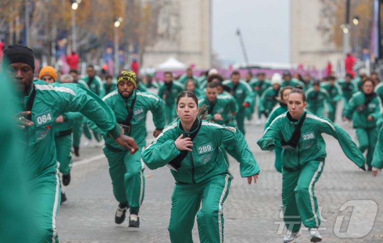 1일(현지시간) 프랑스 파리 샹젤리제 거리에서 열린 넷플릭스 오리지널 시리즈 ‘오징어게임’ 재현 현장 이벤트에서 참가자들이 드라마 속 게임인 ‘무궁화꽃이 피었습니다’에 참여하고 있다.  2024.12.2/뉴스1 ⓒ News1 이준성 기자