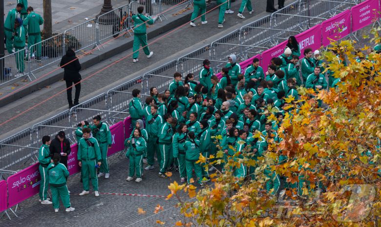 11일(현지시간) 프랑스 파리 샹젤리제 거리에서 열린 넷플릭스 오리지널 시리즈 ‘오징어게임’ 재현 현장 이벤트에서 참가자들이 드라마 속 게임인 ‘무궁화꽃이 피었습니다’에 참여하고 있다.  2024.12.2/뉴스1 ⓒ News1 이준성 기자