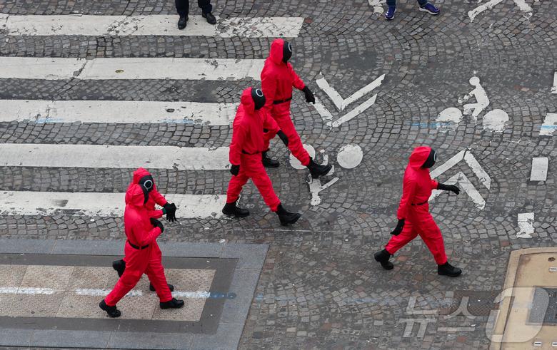1일(현지시간) 프랑스 파리 샹젤리제 거리에서 열린 넷플릭스 오리지널 시리즈 ‘오징어게임’ 재현 현장 이벤트에서 참가자들이 드라마 속 게임인 ‘무궁화꽃이 피었습니다’에 참여하고 있다.  2024.12.2/뉴스1 ⓒ News1 이준성 기자