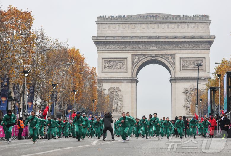11일(현지시간) 프랑스 파리 샹젤리제 거리에서 열린 넷플릭스 오리지널 시리즈 ‘오징어게임’ 재현 현장 이벤트에서 참가자들이 드라마 속 게임인 ‘무궁화꽃이 피었습니다’에 참여하고 있다.  2024.12.2/뉴스1 ⓒ News1 이준성 기자