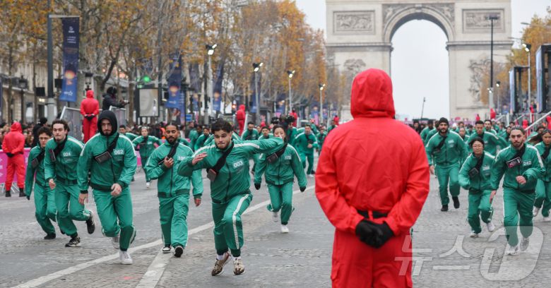 1일(현지시간) 프랑스 파리 샹젤리제 거리에서 열린 넷플릭스 오리지널 시리즈 ‘오징어게임’ 재현 현장 이벤트에서 참가자들이 드라마 속 게임인 ‘무궁화꽃이 피었습니다’에 참여하고 있다.  2024.12.2/뉴스1 ⓒ News1 이준성 기자