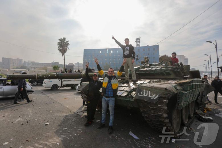 8일(현지시간) 바샤르 알-아사드의 시리아 정부가 붕괴된 뒤 다마스쿠스 우마야드 광장에서 시민들이 장갑차 위에 올라 기뻐하고 있다. 2024.12.09 ⓒ AFP=뉴스1 ⓒ News1 우동명 기자