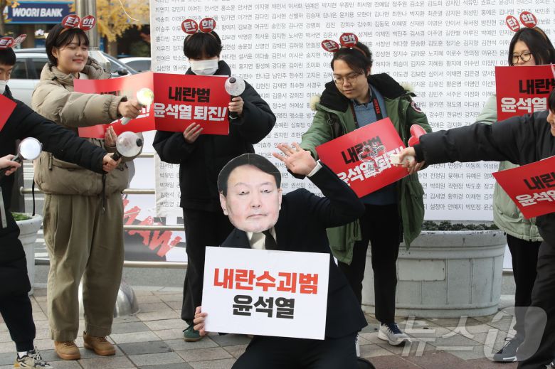 10대부터 30대까지 다양하게 모인 울산 청소년·청년들이 12일 울산 롯데백화점 앞에서 윤석열 퇴진 퍼포먼스를 펼치고 있다.2024.12.12./뉴스1 김세은 기자