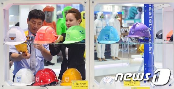 서울 강남구 코엑스에서 열린 '국제안전보건전시회'에서 전시 관계자들이 안전모를 살펴보고 있다. 기사 내용과 관련 없음./뉴스1 ⓒ News1 민경석 기자