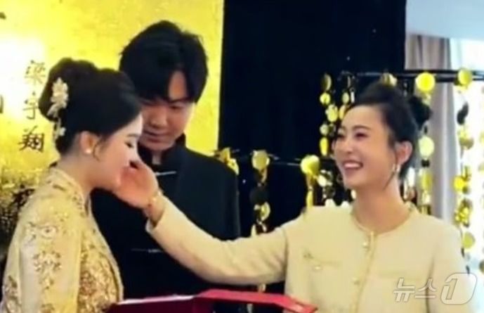 웃으며 며느리의 볼을 만지고 있는 시어머니 - 웨이보 갈무리