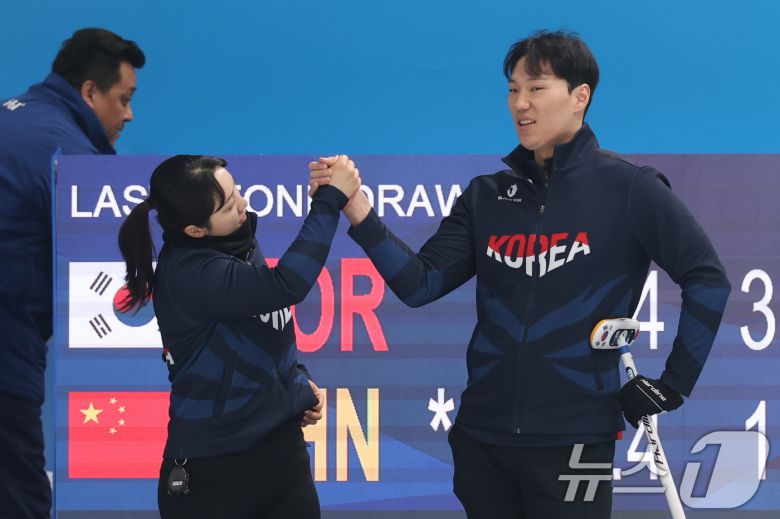 성지훈과 김경애가 6일(현지시간) 중국 헤이룽장성 하얼빈시 핑팡컬링아레나에서 열린 하얼빈 동계아시안게임 컬링 혼성 믹스더블 B조 대한민국과 중국의 경기에서 손을 맞잡고 있다. 2025.2.6/뉴스1 ⓒ News1 이승배 기자
