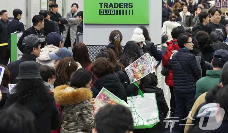 14일 오전 서울 강서구 트레이더스 홀 세일 클럽(이하 트레이더스) 마곡점을 찾은 고객들이 매장 개장 시간 전에 입장을 위해 줄지어 서서 행사 전단을 살펴보고 있다. 트레이더스 마곡점은 지난 2023년 12월 오픈한 수원화서점에 이어 14개월만에 오픈하는 점포로, 월계점에 이어 서울특별시에 2번째로 선보이는 점포다. 2025.2.14/뉴스1 ⓒ News1 김진환 기자