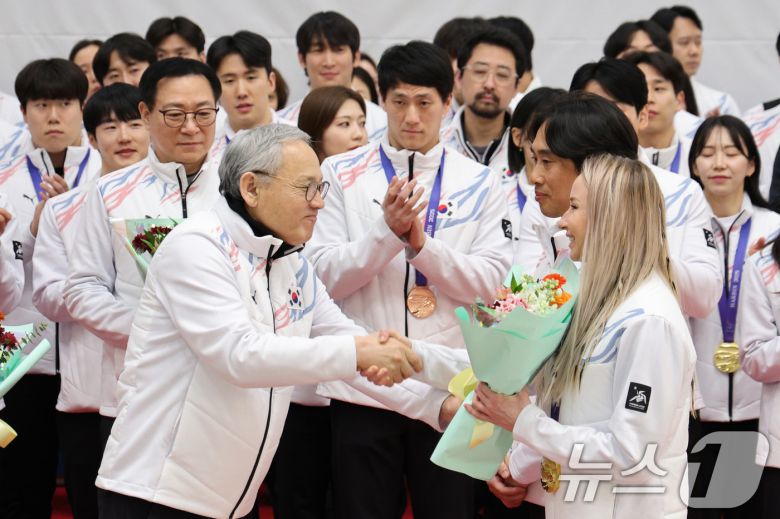 유인촌 문화체육관광부 장관이 15일 오후 인천국제공항 1터미널 귀국장에서 열린 2025 하얼빈 동계 아시안게임 한국 선수단 귀국 환영 행사에서 귀화 선수로서 한국 바이애슬론 사상 첫 동계아시안게임 금메달을 획득한 예카테리나 압바꾸모바에게 꽃다발을 전달하고 있다. 8년 만에 열린 이번 대회에 한국은 총 222명의 선수단을 파견해 금메달 16개, 은메달 15개, 동메달 14개를 수확하며 개최국 중국(금 32·은 27·동 25)에 이어 종합 2위를 차지했다. 2025.2.15/뉴스1 ⓒ News1 신웅수 기자