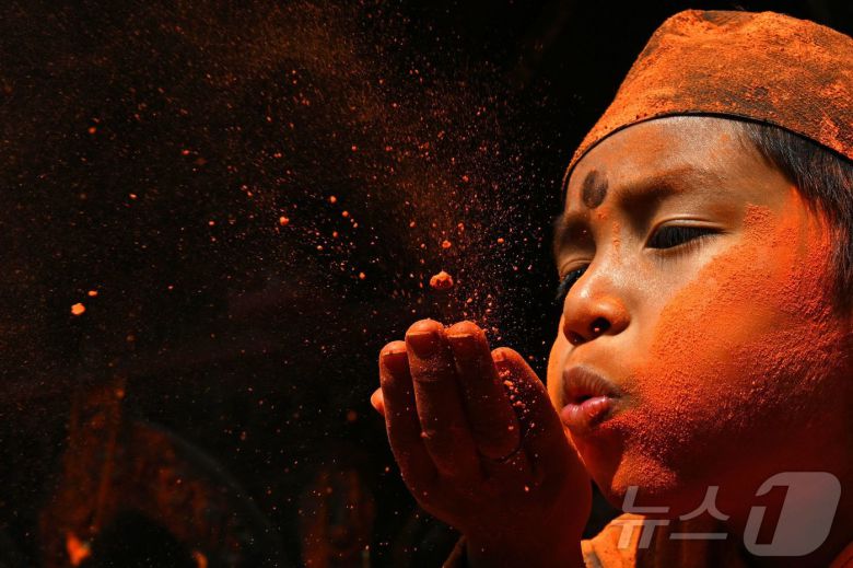 15일(현지시간) 네팔 카트만두에서 열린 신두르 자트라 축제에서 시민들이 주홍 가루를 뿌리며 축제를 즐기고 있다.  ⓒ AFP=뉴스1