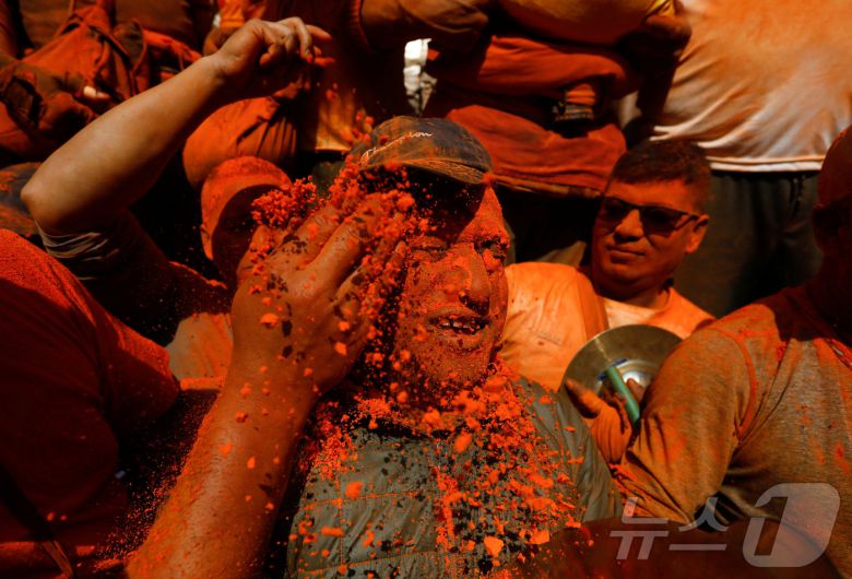 15일(현지시간) 네팔 박타푸르에서 열린 신두르 자트라 축제에서 시민들이 주홍 가루를 얼굴에 바르고 있다. ⓒ 로이터=뉴스1