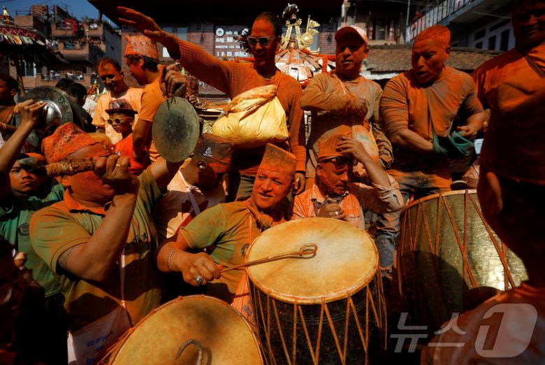 15일(현지시간) 네팔 박타푸르에서 열린 신두르 자트라 축제에서 시민들이 주홍 가루를 뿌리며 축제를 즐기고 있다.ⓒ 로이터=뉴스1