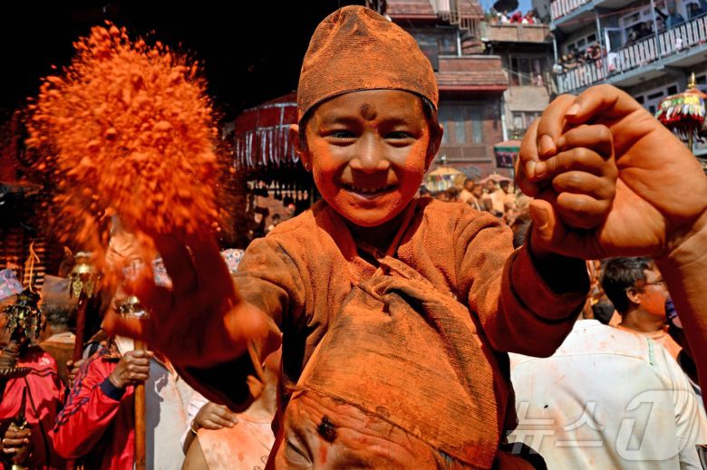 15일(현지시간) 네팔 카트만두에서 열린 신두르 자트라 축제에서 시민들이 주홍 가루를 뿌리며 축제를 즐기고 있다.  ⓒ AFP=뉴스1