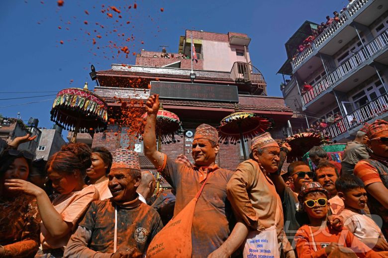 15일(현지시간) 네팔 카트만두에서 열린 신두르 자트라 축제에서 시민들이 주홍 가루를 뿌리며 축제를 즐기고 있다. ⓒ AFP=뉴스1